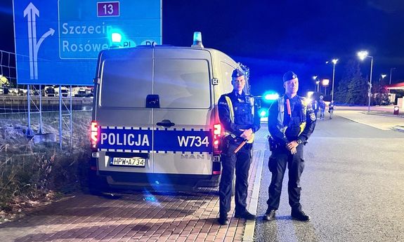 Dwaj policjanci przy radiowozie.
