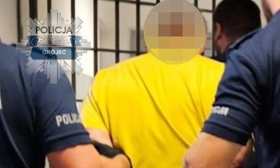 Dwaj policjanci prowadzą zatrzymanego.