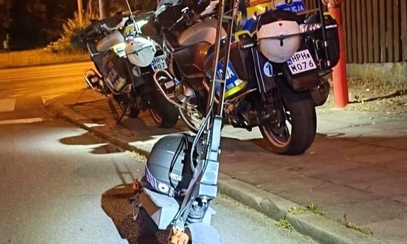 hulajnoga, w tle stoją dwa motocykle.