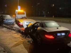 Dwa rozbite auta. Jedno z nich jest wciągane na lawetę.