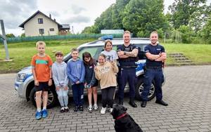 Policjanci pozują do zdjęcia z grupą dzieci.