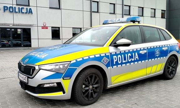 Policyjny radiowóz zaparkowany przed komendą.