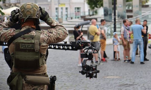 policjant stoi plecami do aparatu.