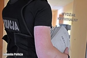 Policjant niesie akta.