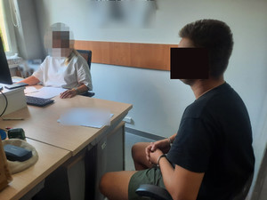 zatrzymany siedzi na krześle.