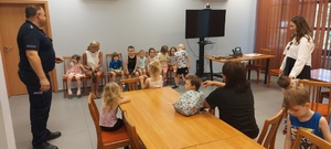 Policjant podczas spotkania profilaktycznego z dziećmi i ich opiekunami.