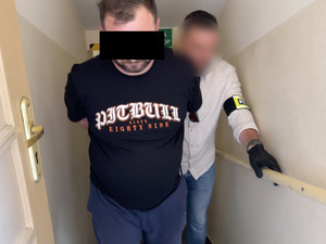 policjant idzie z zatrzymanym.