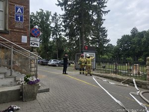 Policjant rozmawia ze strażakami.