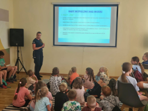 Policjantka z grupą dzieci podczas spotkania profilaktycznego.