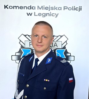 Policjant w mundurze pozuje do zdjęcia.