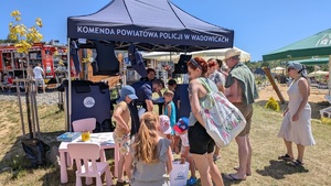 Policjanci przy stoisku profilaktycznym rozmawiają z uczestnikami wydarzenia.