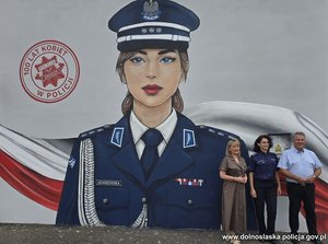 Mural przedstawiający wizerunek policjantki i trzy osoby na jego tle.
