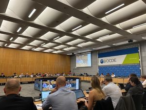 Uczestnicy spotkania zgromadzeni na sali w siedzibie głównej OECD w Paryżu.