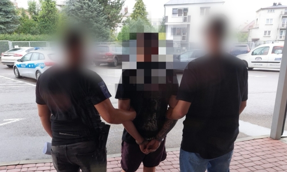 Dwaj funkcjonariusze z zatrzymanym mężczyzną.