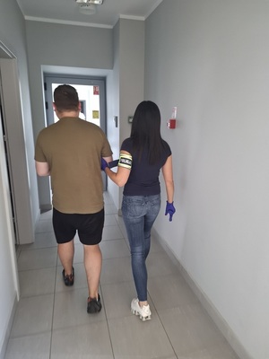 policjantka idzie z zatrzymanym.