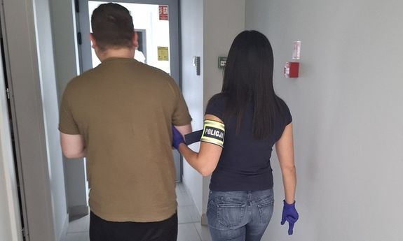 policjantka idzie z zatrzymanym.
