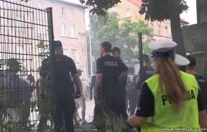 Policjanci zabezpieczają miejsce, w którym zebrało się kilkadziesiąt osób.