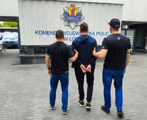 Policjanci po cywilnemu z zatrzymanym mężczyzną.