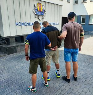 Policjanci po cywilnemu z zatrzymanym mężczyzną.