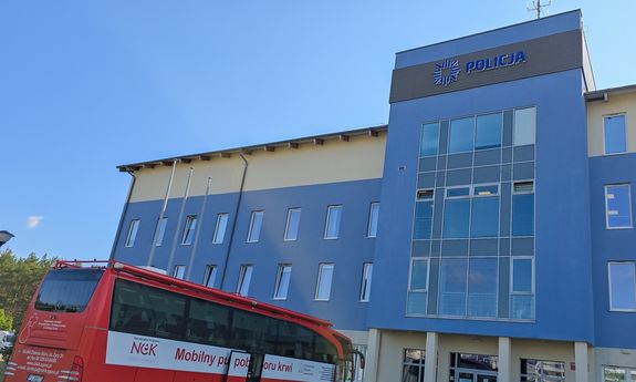 Mobilny punkt poboru krwi stojący przed budynkiem komendy.