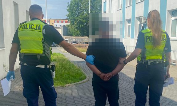 Policjanci idą z zatrzymanym.