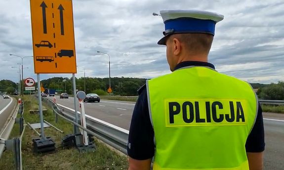 Policjant stoi przed przejściem granicznym.