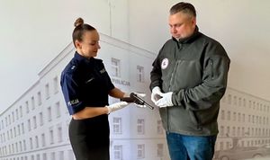 Mężczyzna i policjantka. Kobieta trzyma w ręku broń.