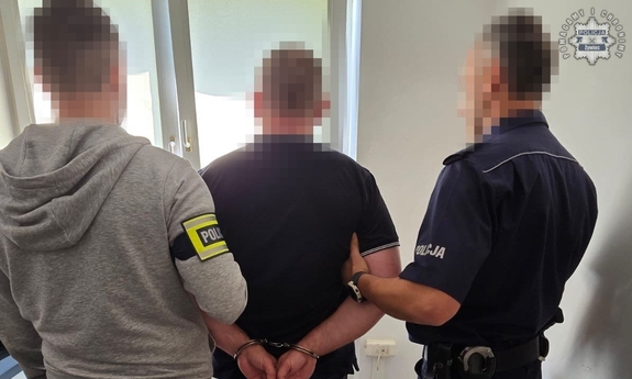 Policjanci prowadza zatrzymanego.