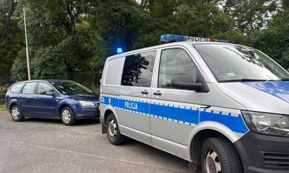 Bus policyjny eskortuje samochód do szpitala.