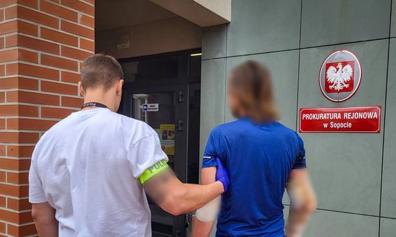 Zatrzymany prowadzony przez policjanta.