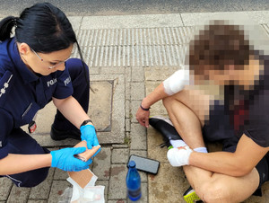 Policjantka udzielająca pomocy rowerzyście.