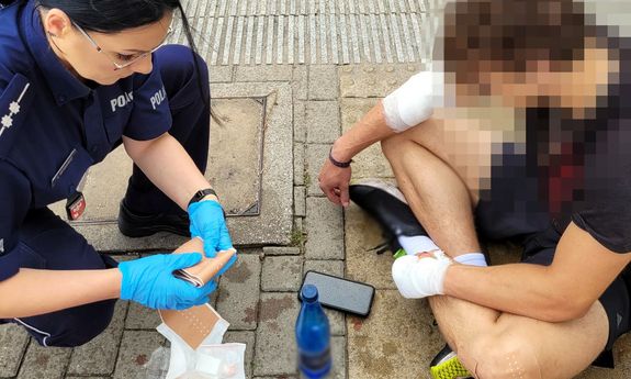 Policjantka udzielająca pomocy rowerzyście.