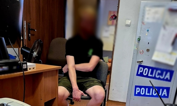 Zatrzymany mężczyzna siedzi na krześle podczas przesłuchania.