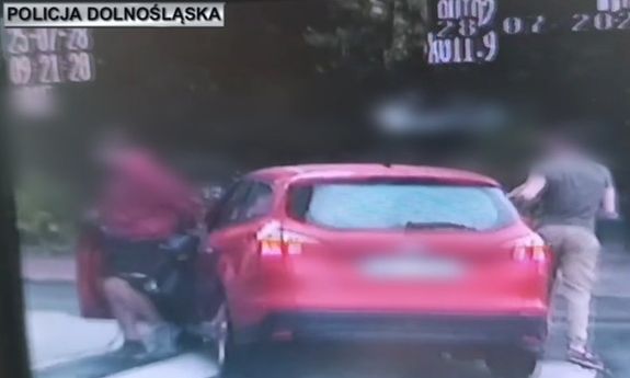 Dwaj mężczyźni wybiegający z auta - stop klatka z nagrania video.