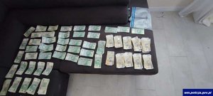 Banknoty rozłożone na kanapie.