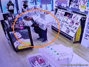 Zdjęcie z kamery przemysłowej w sklepie pokazujące mężczyznę kradnącego towar.