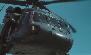 Zbliżenie na kabinę policyjnego śmigłowca Black Hawk, w kabinie widoczny pilot.