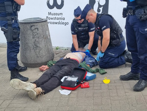 Policjanci prowadzą resuscytację krążeniowo-oddechową mężczyzny.