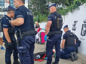 Policjanci prowadzą resuscytację krążeniowo-oddechową mężczyzny.