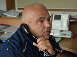 Policjant rozmawia przez telefon.