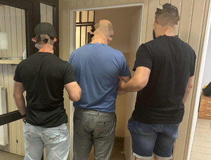 Policjanci prowadzą zatrzymanego.