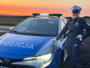 policjantka stoi obok radiowozu.