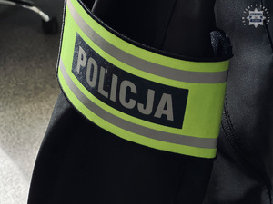 Opaska z napisem Policja na ramieniu.