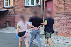 policjanci prowadzą zatrzymanego.