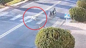 Stopklatka z nagrania monitoringu przedstawia kobietę leżącą na jezdni i odjeżdżający motocykl.