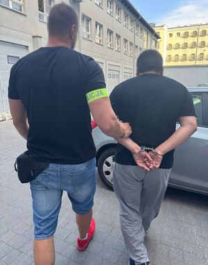 Policjant z zatrzymanym mężczyzną.