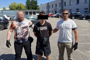policjanci prowadzą zatrzymanego.