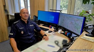 policjant siedzi przy biurku.