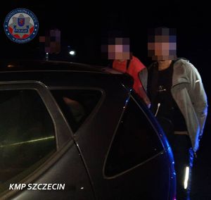 Nielegalni migranci przy samochodzie.