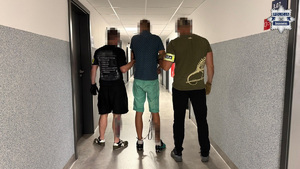 Dwaj policjanci prowadza zatrzymanego.